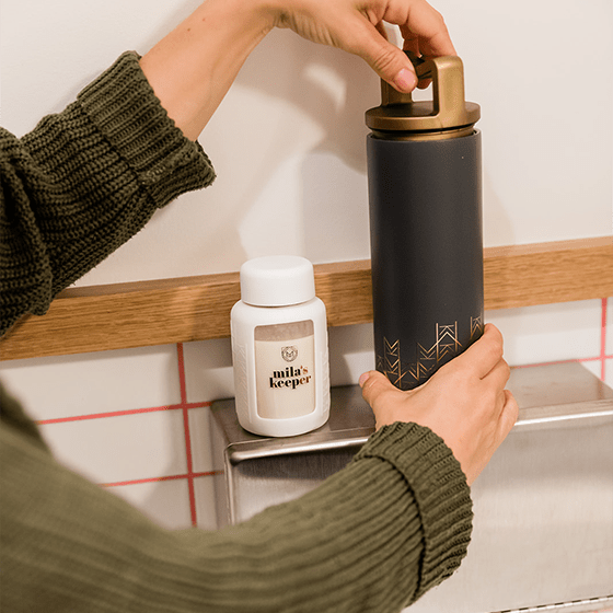 Mila's Keeper Insulated Breast Milk Cooler in Starry Night and Breast Milk Storage Bottles in Aspen White - pumping in public bathroom