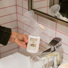 Mila's Keeper Glass Breast Milk Storage Bottle with pump in bathroom